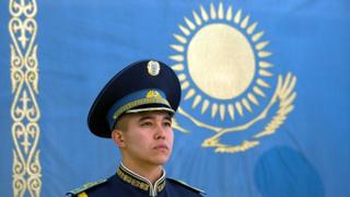Казахстанский военный на фоне национального флага