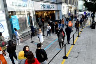 Customers queue to enter a Primark store