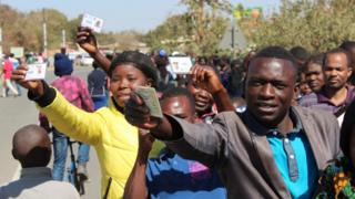 voters hold out id cards in lusaka
