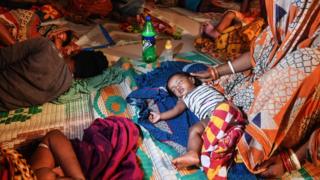 People evacuated for safety rest in a temporary cyclone relief shelter in Puri in the eastern Indian state of Odisha