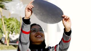 काठमाण्डूबाट सूर्य ग्रहण हेर्दै एक महिला