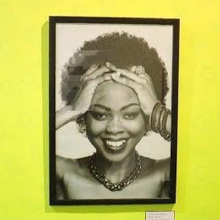 Sur le mur, une succession de photographies d'hommes et de femmes ayant des cheveux naturels.