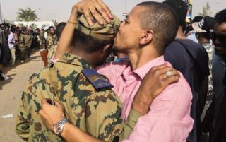 A Sudanese anti-regime protester kisses a soldier on the head during protests in Khartou, Sudan - Thursday 11 April 2019