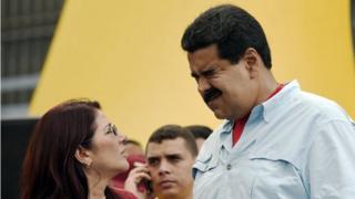Президент Венесуэлы Николас Мадуро (справа) жестами рядом с первой леди Силией Флорес во время митинга в Каракасе 8 августа 2015 года