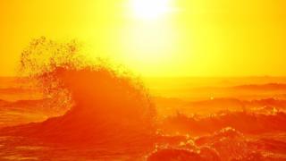 Sea breaks under sun