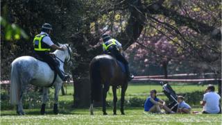 Police on horses speaking to a family