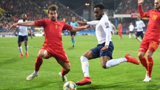 Danny Rose of England takes on Filip Stojkovic (2) and Mirko Ivanic of Montenegro (20) during the 2020 UEFA European Championships Group A qualifying match between Montenegro and England