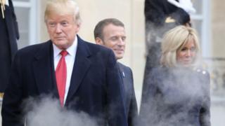 Khói bay ra từ ống xả chiếc xe hơi có tên The Beast đón Tổng thống Donald Trump khi ông chia tay Tổng thống Pháp Emmanuel Macron (giữa) và phu nhân Brigitte Macron (phải) tại Điện Elysee ở Paris vào ngày 10/11/2018