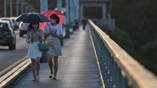 Women walking across bridge in Wuhan city