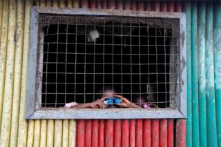 Children examine pair of toy binoculars in Nsuaem Top town, Ghana - November 24, 2018