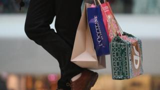 Homem segurando sacolas de compras