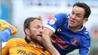 Carlisle's Luke Joyce climbs above Sean Rigg of Newport County
