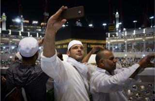 Muslim pilgrims take picture near the Islam's holiest shrine, the Kaaba, at the Grand Mosque in the Saudi holy city of Mecca, late on September 20, 2015. The annual hajj pilgrimage begins on September 22, and more than a million faithful have already flocked to Saudi Arabia in preparation for what will for many be the highlight of their spiritual lives.