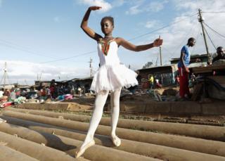 A young ballerina poses for a photo during a ballet street performance to showcase their skills in Kibera slum, Nairobi, Kenya - Saturday 30 November 2018