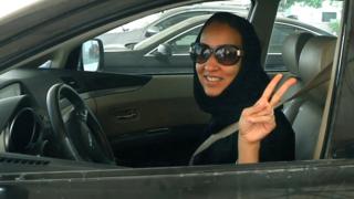 Активист из Саудовской Аравии Манал Аль Шариф показывает знак победы в своей машине 22 октября 2013 года