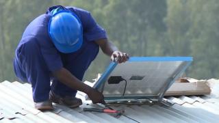 Un trabajador instala una placa solar.