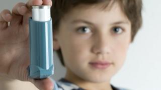 Boy holding blue inhaler