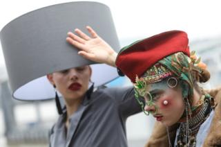 Participants pose for photographs as they take part in a Hat Walk