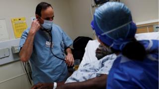 Врач осматривает пациента, находящегося под наблюдением на предмет коронавирусной болезни (COVID-19) в отделении неотложной помощи больницы Roseland Community Hospital в южной части Чикаго, штат Иллинойс