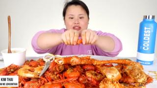 KimThai comiendo un plato de marisco