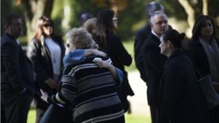 Женщины обнимаются, когда прибывают за пределы собрания Родефа Шалома, где состоятся похороны для расстрелянных жертв Сесила Розенталя и Дэвида Розенталя