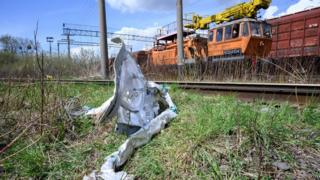Shards of twisted metal from a Russian rocket are seen in undergrowth near a train line on 25 April 2022 near Lviv, Ukraine