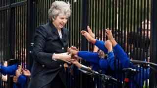 Theresa May is greeted by pupils during her visit to Dunraven School in South London on Monday