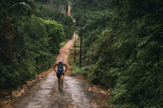 Mina Guli treks up a muddy path near the Amazon River in Brazil