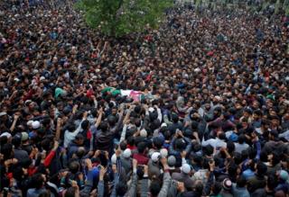Люди несут тело профессора Кашмира Мохаммада Рафи Бхата, подозреваемого боевика, после того, как он был убит в перестрелке с индийскими силами безопасности в южном Кашмире во время его похоронного шествия в деревне Чундуна в районе Гандербал 6 мая 2018 года