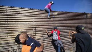 Centenares de migrantes, incluyendo mujeres y niños, intentaron cruzar hacia EE.UU. saltando una valla en la frontera con México.
