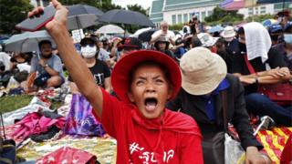Pro-democracy protesters gesture during a protest at Thammasat University in Bangkok, 19 September