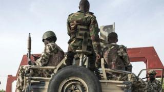 Nigerian soldiers dey on top and around car