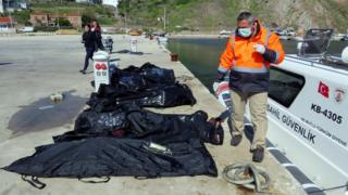 A rescuer walks next to bodies of refugees and migrants in body bags laid on a pier next to a Turkish coast guard vessel, after an inflatable boat carrying refugees and migrants sank off the Greek island of Lesbos and at least 16 people drowned, at the Aegean port village of Babakale in Canakkale province, Turkey, 24 April 2017