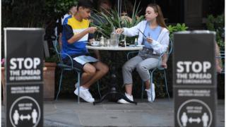 Young couple sitting at a restaurant in London at the start of the government's Eat Out to Help Out scheme
