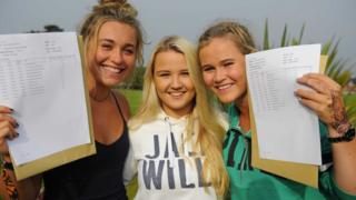 Счастливые студенты Александра Адамс, Кэти Фишер и Кэтрин Хилл собирают свои результаты в Салливан Аппер