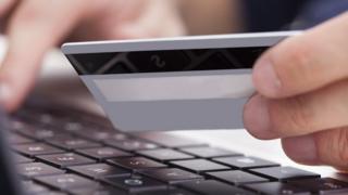 A person uses a credit card to buy online