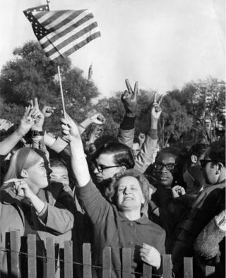 Viola Woods, of Boston, waved an American flag and shouted, "Hooray for President Nixon," amid the crowd on Moratorium Day rally crowd on Boston Common, Oct. 15, 1969