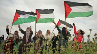 نساء فلسطينيات يحملن علم فلسطين