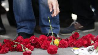 Люди возлагают цветы на землю на второй день после взрывов после антиправительственной акции протеста в Анкаре, Турция