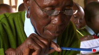 90-year-old Kenyan student Priscilla Sitienei , in school uniform, holding a pencil