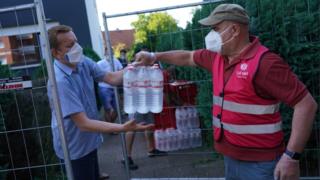 Workers hand out supplies to residents quarantined in Gutersloh