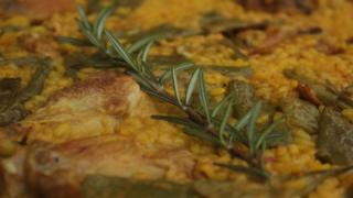 Paella con una rama de romero.