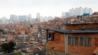 Casas em Paraisópolis, com prédios ao fundo