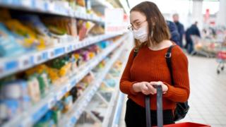 A woman wearing a facemask in a supermarket