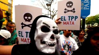Протестующие держат плакаты против Транстихоокеанского партнерства (ТТП) во время митинга в кулуарах саммита Азиатско-Тихоокеанского экономического сотрудничества (АТЭС) в Лиме