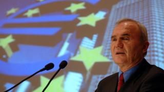 Otmar Issing frente a una bandera de la UE.