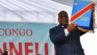 Democratic Republic of the Congo's newly inaugurated President Felix Tshisekedi raises an official copy of the nation's constitution on January 24, 2019