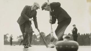 Men playing curling on ice