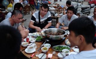 На этом снимке, сделанном 9 мая 2016 года, люди едят собачье мясо в ресторане в Юйлине, в южном китайском регионе Гуанси.