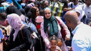 People fleeing war-torn Sudan queue to board a boat from Port Sudan on April 28, 2023